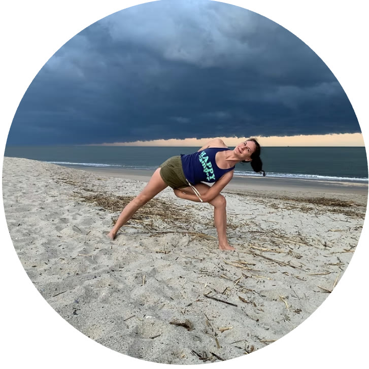 A deep lunge twist on the beach under a rolling storm sky